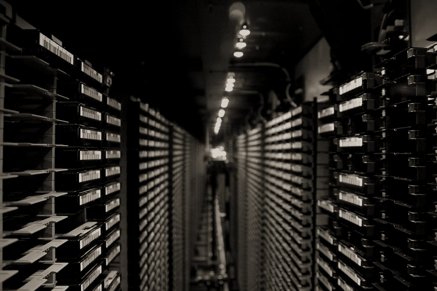 Allée d’archives de calcul en perspective, éclairée par une lumière rasante