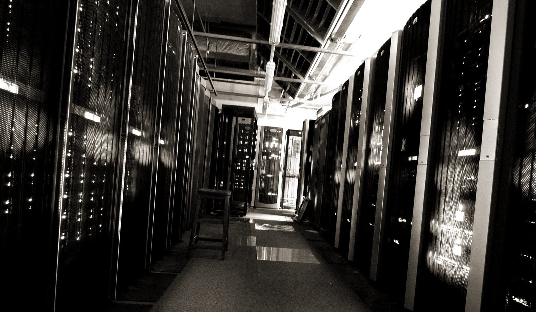 Allée de baies informatiques dans une salle technique sécurisée
